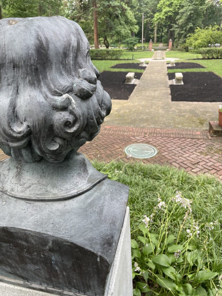 A central flagstone walk on the British Cultural Garden's upper level leads to a bust of William Shakespeare. The bust was created by sculptors Joseph Motto and Stephen Rebeck.